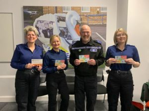 four PCSO holding up a Community Connector's postcard